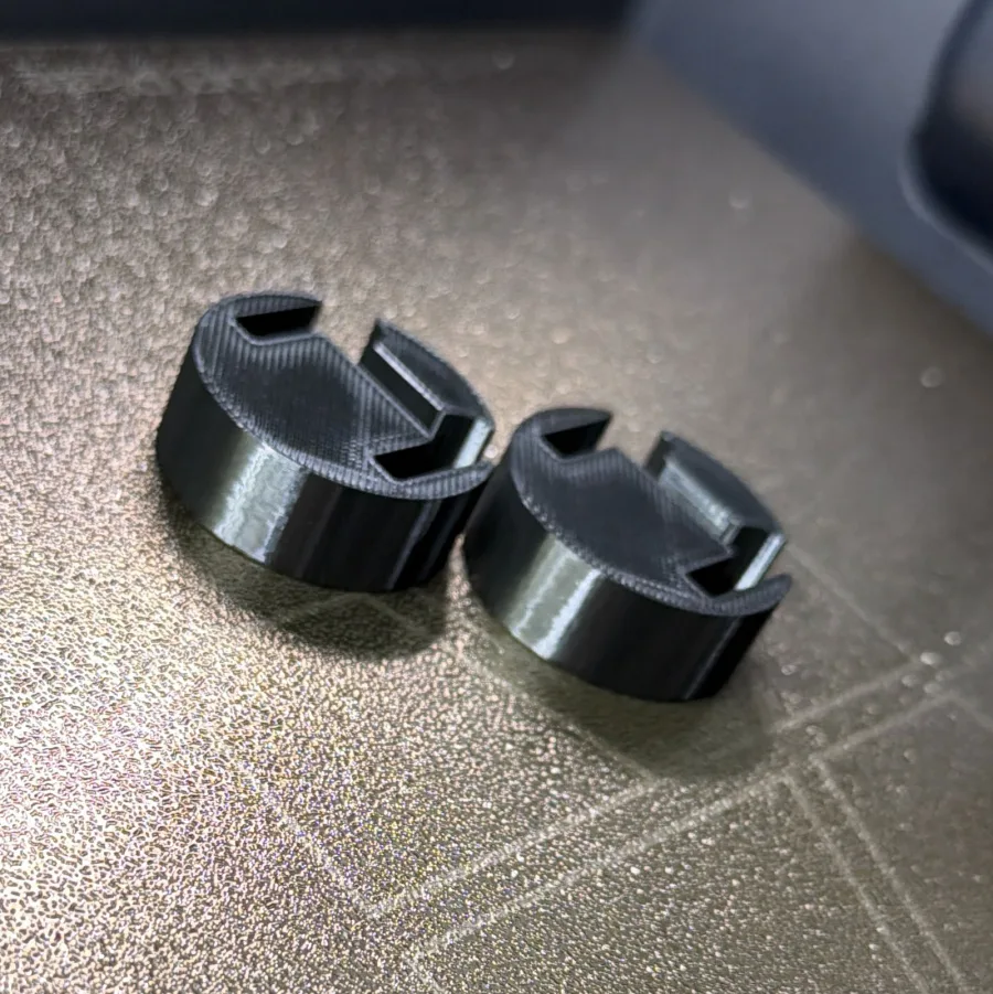 Twee zwarte 3D-geprinte PETG-beugels als vervangend onderdeel